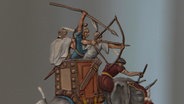 Fabrig bemalte Zinnfigur eines Kriegelefanten mit Bogenschützen und Lanzenträgern auf dem Rücken © Screenshot 