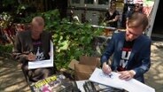 Max Kielhauser und Jan Koppens signieren ihr Buch "Pauliebe" © Screenshot 