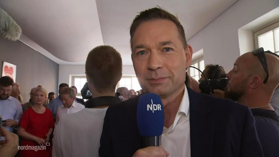 NDR Reporter Roman Schmelter berichtet live aus Schwerin. © Screenshot 