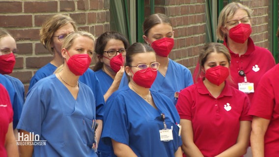 Klinikpersonal demonstriert mit roten FFP2-Masken gegen die strukturelle Unterfinanzierung des Gesundheitssektors. © Screenshot 