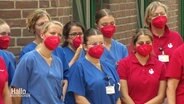 Klinikpersonal demonstriert mit roten FFP2-Masken gegen die strukturelle Unterfinanzierung des Gesundheitssektors. © Screenshot 