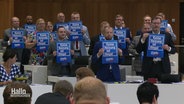 AfD-Abgeordnete halten im Landtag kleine Plakate hoch mit dem Text "Keine Heizung ist illegal". © Screenshot 