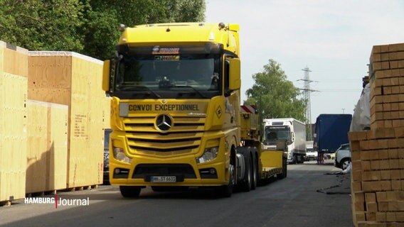 Gelber Lastkraftwagen mit der Aufschrift Convoi Exceptionnel steht zentrl auf einer Straße. © Screenshot 