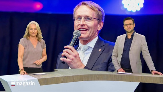 Zwei Moderatoren stehen links und rechts an einem Tresen. In der Mitte ist ein Bildschirm, der Daniel Günther, den Ministerpräsidenten von Schleswig-Holstein zeigt. © Screenshot 