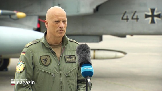 Auf dem Bild sieht man Ingo Gerhartz (deutscher Generalleutnant). Er steht vor einem NATO-Kampfjet. © Screenshot 