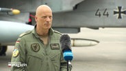 Auf dem Bild sieht man Ingo Gerhartz (deutscher Generalleutnant). Er steht vor einem NATO-Kampfjet. © Screenshot 