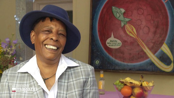 Auf dem Bild kann man Marla Glen erkennen. Eine Soul-Jazz-Sängerin. Sie trägt einen blauen Hut und einen karierten Blazer. © Screenshot 
