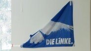 Ein halb abgerissener Banner mit der Aufschrift "Die Linke" © Screenshot 