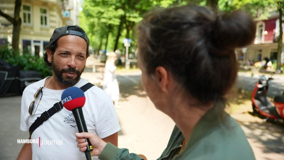 Ein Mann mit einer Basketballcap und Bart wird interviewt © Screenshot 