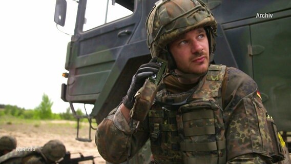 Ein Soldat sitzt vor einem Militärfahrzeug. © Screenshot 