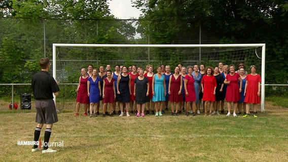 Eine Gruppe von Frauen steht in einem Fußballtor auf einem Rasen im Freien. © Screenshot 
