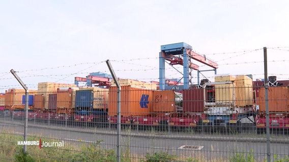 Container stehen auf der anderen Seite eines Stacheldrahtzauns. © Screenshot 