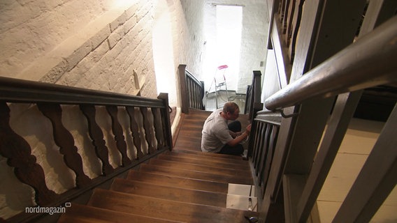 Eine Person sitzt auf einer Treppe © Screenshot 