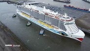 Aus der Vogelsperspektive: Das Kreuzfahrtschiff AIDA im Hamburger Hafen, begleitet von Schleppern. © Screenshot 