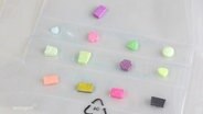 Mehrere Ecstasy-Tabletten liegen in bunten Farben auf einem Tisch. © Screenshot 