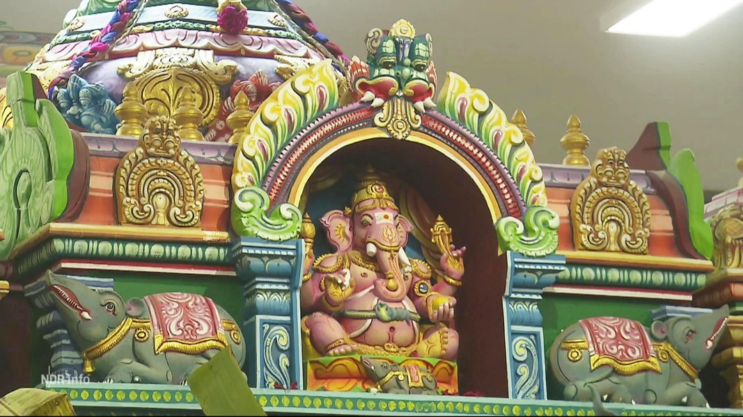 Auf einem bunten, kunstvoll verzierten Altar prangt die Statue des indischen Gotts Ganesha in seiner Erscheinung mit Elefantenkopf.
