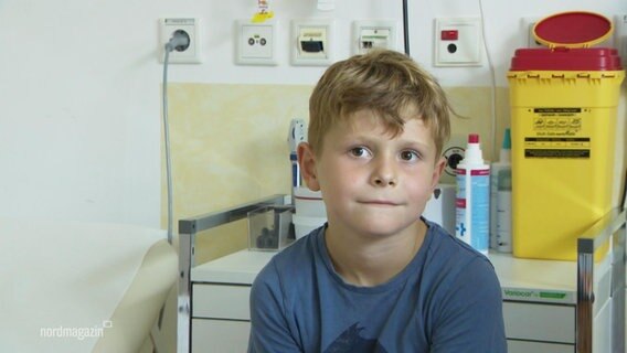 Ein Junge sitzt auf einem Krankenhausbett © Screenshot 