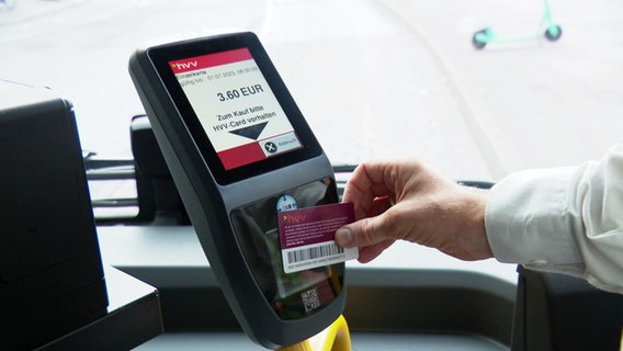 Ein Mann hält eine HVV-Prepaid-Card vor ein Lesegrät in einem Bus. © Screenshot 