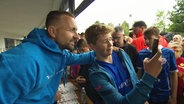 Spieler von Hansa Rostock (Verhoek) macht Selfie mit Fan. © Screenshot 