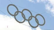 Die olympischen Ringe hängen als Dekoration in der Luft. © Screenshot 