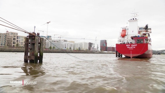 Blick auf das Gewässer neben der Hamburger Hafen City, in dem ein Schiff mit rotem Rumpf schwimmt. © Screenshot 