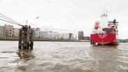 Blick auf das Gewässer neben der Hamburger Hafen City, in dem ein Schiff mit rotem Rumpf schwimmt. © Screenshot 