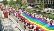 Kiel beim CSD 2023: Menschen tragen eine riesige Regenbogenflagge durch die Innenstadt. © Screenshot 