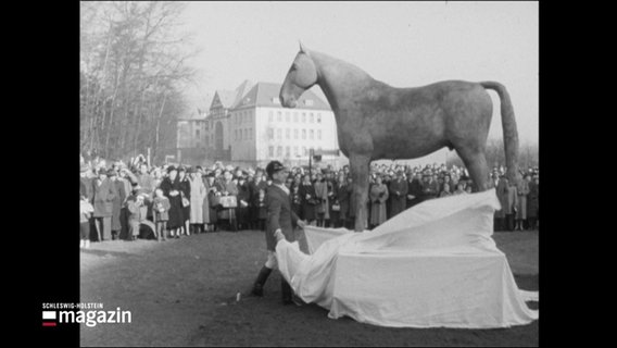 Eine schwarz-weiße Aufnahme: Fritz Tiedemann enthüllt die Statue von seinem Holsteiner "Meteor" in Kiel. © Screenshot 