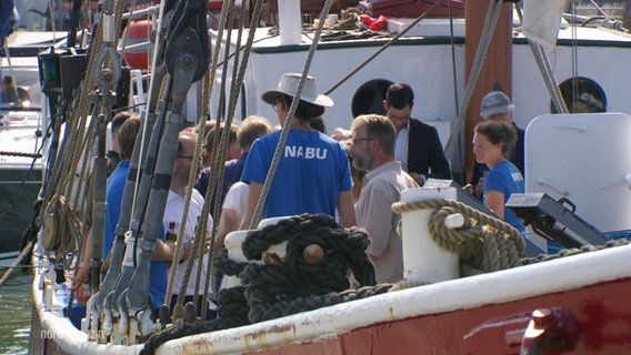 Eine Menschenmenge an Board eines alten Segelschiffs. Ein Mann trägt ein blaues NABU T-Shirt. © Screenshot 