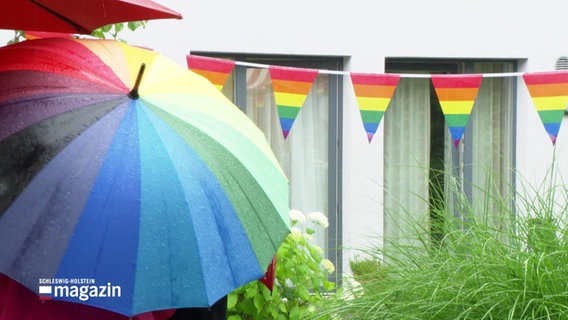 Regenschirme und Wimpel in Regenbogenfarben. © Screenshot 