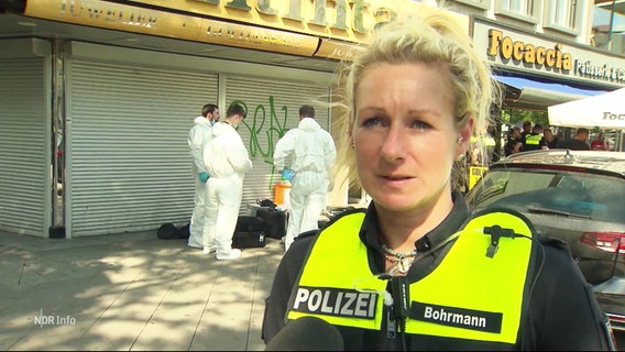 Eine Polizeibeamtin vor einem Juweliergeschäft. © Screenshot 