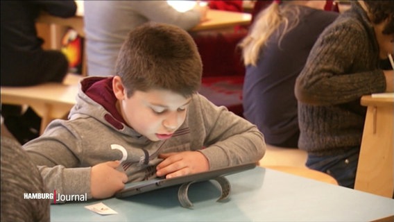 Kind über ein tablet gebeugt © Screenshot 