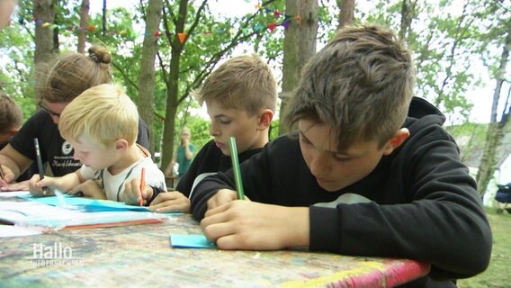 Kinder schreiben Briefe in einem Ferienlager. © Screenshot 