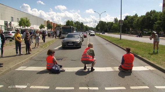 Aktivisten der "letzten Generation" blockieren eine Straße. © Screenshot 