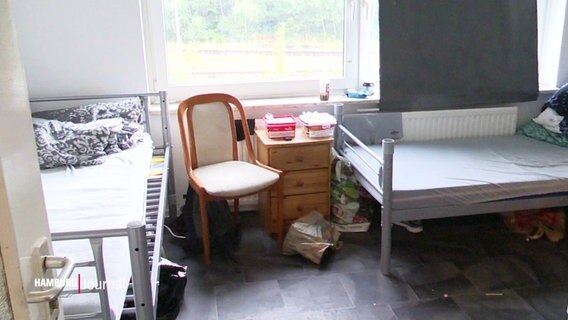 Zwei Betten und ein Stuhl stehen in einem Raum. © Screenshot 