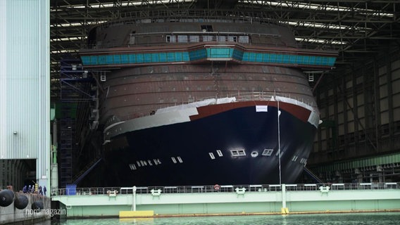 Ein Kreuzfahrtschiff in einer Dockhalle. © Screenshot 