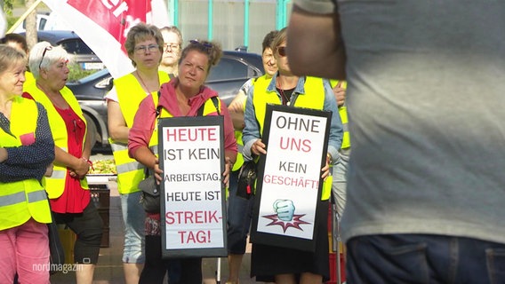 Mehrere Frauen haben gelbe Warnwesten an und halten Streikschilder in den Händen. © Screenshot 