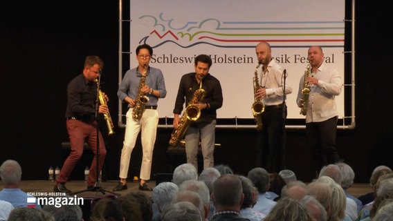 Fünf Saxophonspieler auf der Bühne. © Screenshot 
