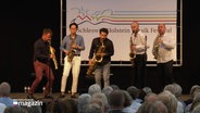 Fünf Saxophonspieler auf der Bühne. © Screenshot 