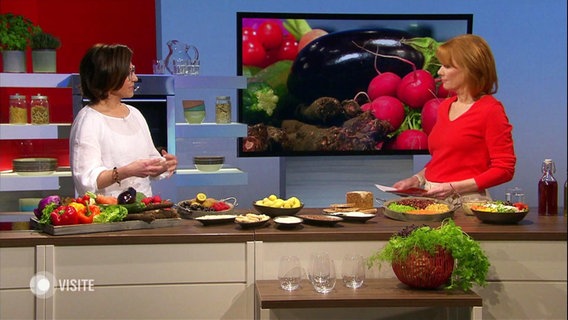 Ernährungs-Doc Silja Schäfer und Moderatorin  Vera Cordes im Studio, vor Ihnen liegen verschiedene Gemüsesorten und andere Lebensmittel. © Screenshot 