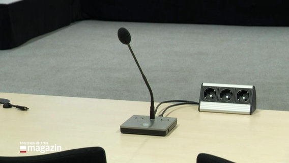 Ein Mikrofon steht in einem Gerichtssaal. © Screenshot 