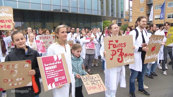Medizinstudierende in Greifswald demonstrieren mit Plakten für ein faires Praktisches Jahr. © Screenshot 