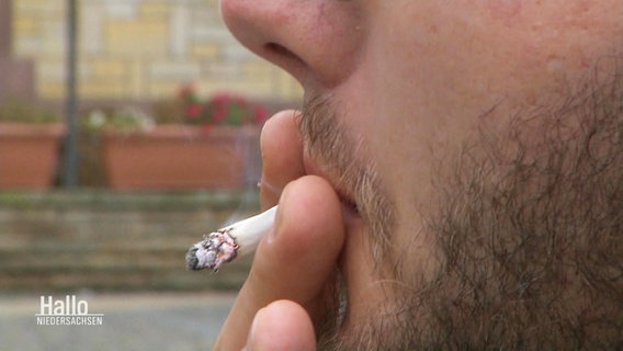 Nahaufnahme von einer Person mit Bart, die an einer Zigarette zieht. © Screenshot 