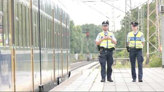 Die Polizei patroulliert an einem Bahnsteig. © Screenshot 