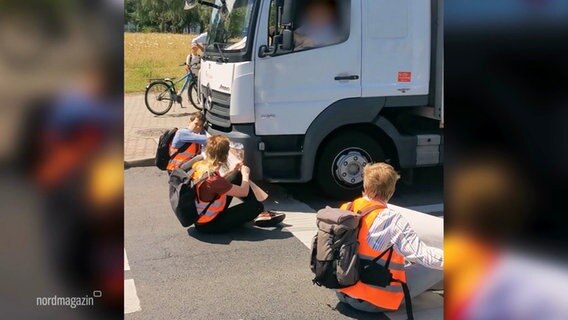 Ausschnitt eines Videos: EIn LKW fährt einen Aktivisten der "Letzten Generation" an, der auf einer Straße sitzt. © Screenshot 