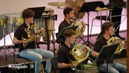 Vier junge Musiker spielen in einem Orchester das Horn © Screenshot 