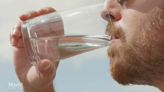Ein Mann trinkt aus einem Glas Wasser. © Screenshot 