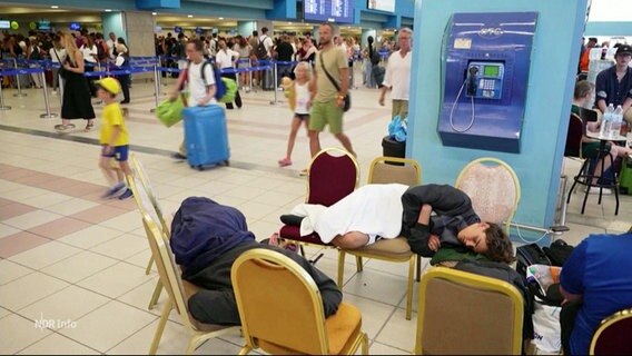 Urlauber schlafen auf Stühlen am Flughafen auf Rhodos. © Screenshot 