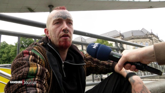 Ein Mann wird vom NDR mit einem Mikrofon interview. © Screenshot 