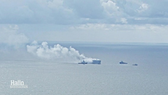 Auf dem offenen Meer steigen große Rauchwolken von einem Frachter empor, daneben einige kleinere Schiffe. © Screenshot 